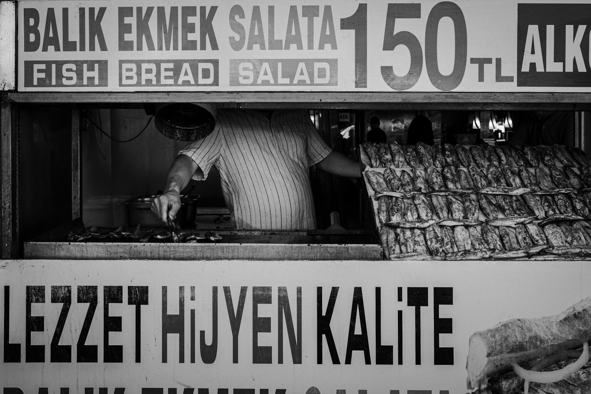 에미뇌뉘 선착장 근처에서 판매하는 고등어 케밥의 가격표와 함께 조리 중인 생선들이 보입니다.